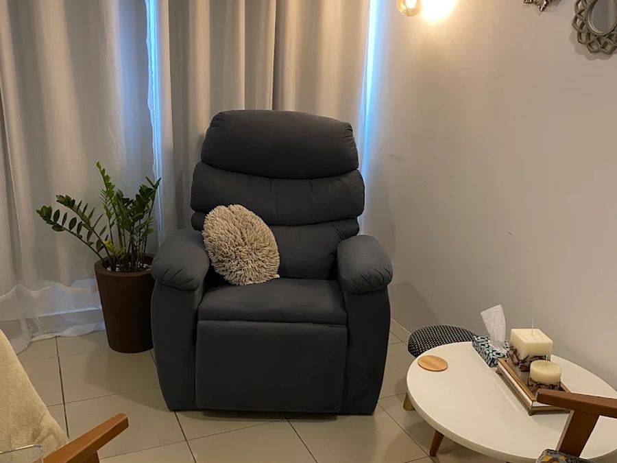 Sala de atendimento com poltrona reclinável, planta e luminária pendente